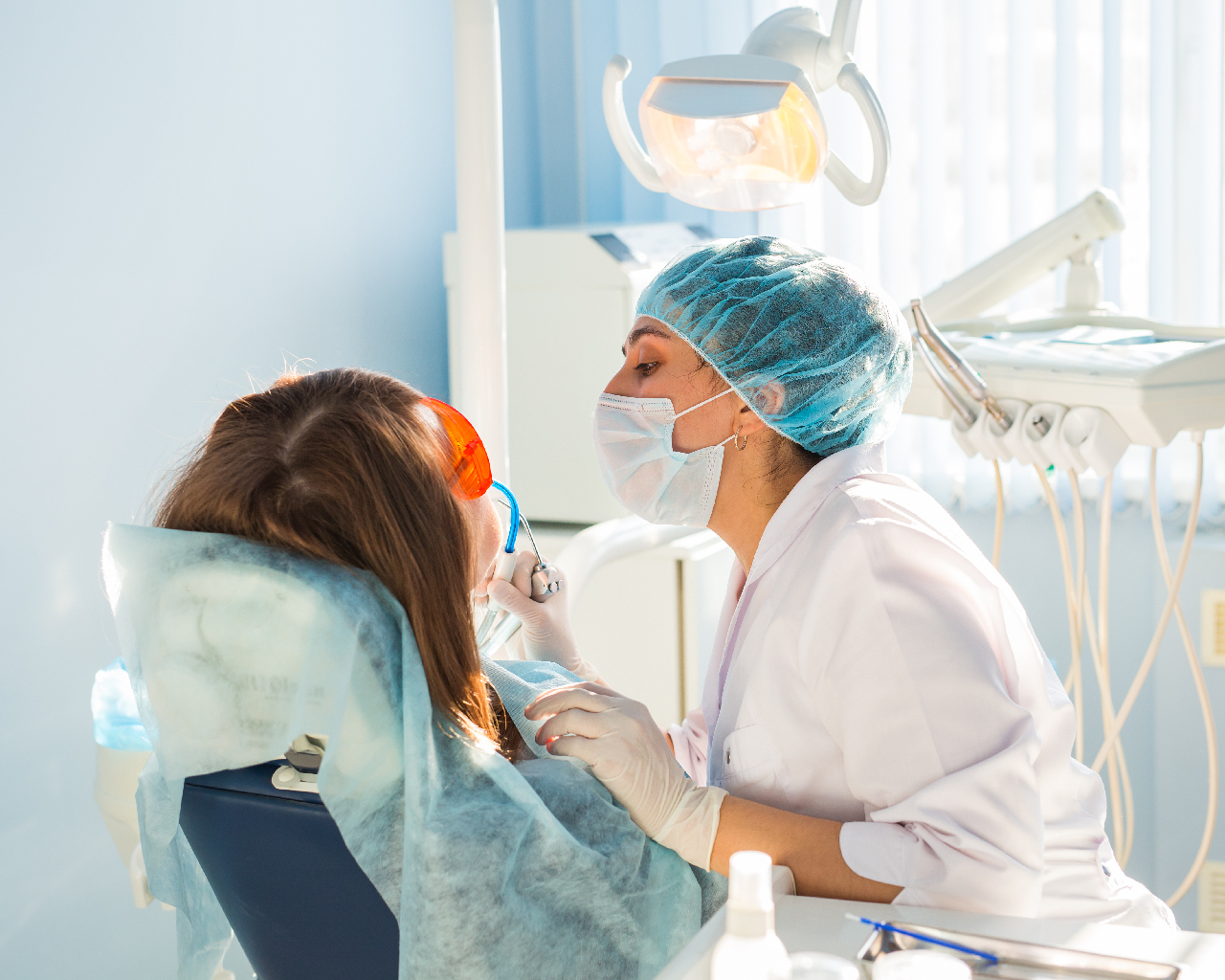 Woman at the dentist's chair during a dental procedure lad dentist using invisalign itero intraoral scanner