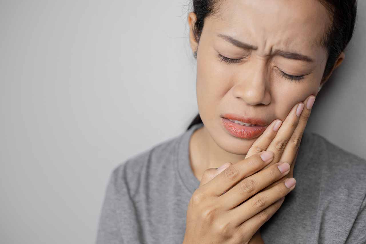 Asian lady suffering from damaged teeth resulting from her impacted wisdom teeth | wisdoom extraction singapore