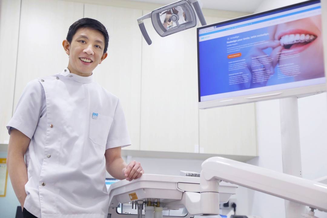 Dr-Joshua-Chong dentist standing beside dental chair