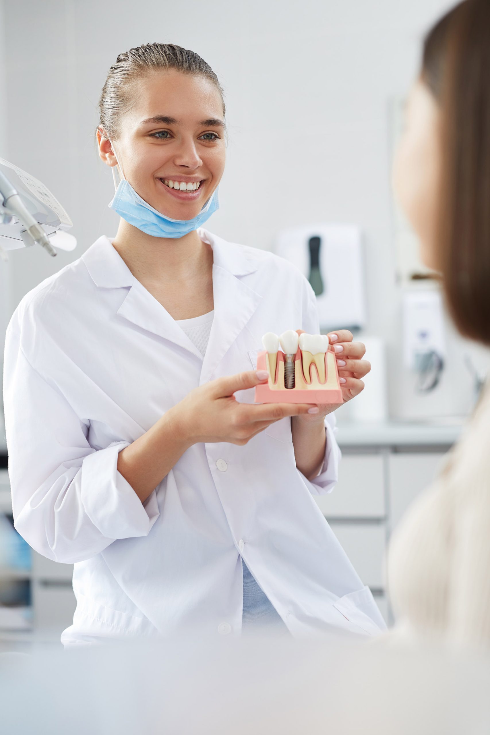dentist holding a dental implant model dentist holding a dental implant model